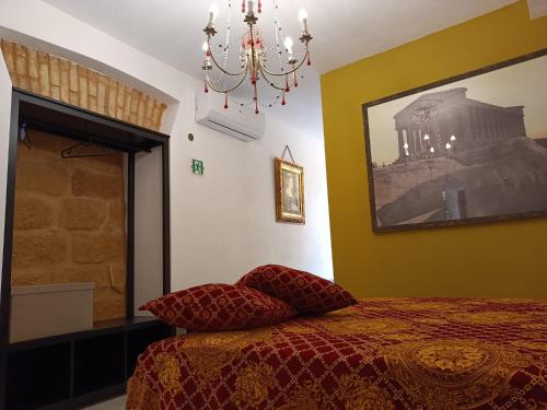 um quarto com uma cama e um lustre em A Cantunera LittleHouse em Agrigento