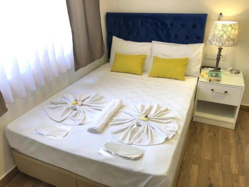 a bed with two white plates and napkins on it at Turunç Hotel ANTALYA in Antalya