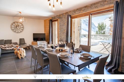 a dining room with a table and chairs and a large window at MARMOTTE 001 - Bel appartement avec grande terrasse, aux pieds des pistes in Bonneval-sur-Arc