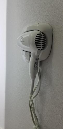 a white hairdryer hanging on a wall at DAY N NIGHT Inn in Los Angeles