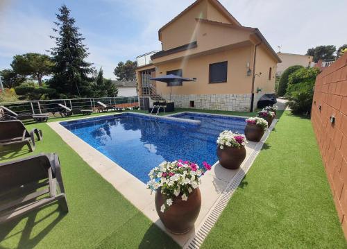 una piscina con macetas y una casa en Raco de Lis, en La Torre de Claramunt