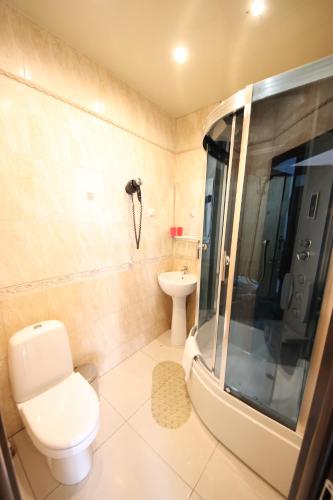 a bathroom with a toilet and a shower and a sink at OLO Marsel Krasnodar Hotel in Krasnodar