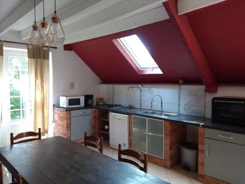 une cuisine avec une table et une cuisine avec une fenêtre dans l'établissement Gîte Le Pressoir, à Catteville