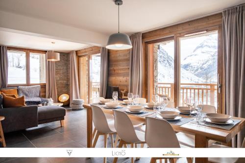 a dining room with a table and chairs and mountains at MARMOTTE 104 - Charmant T4, aux pieds des pistes in Bonneval-sur-Arc