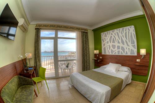 a bedroom with a bed and a large window at Hotel & Spa Entremares in La Manga del Mar Menor