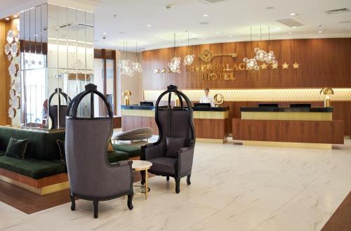 a lobby of a hotel with chairs and a counter at River Palace Hotel in Saint Petersburg