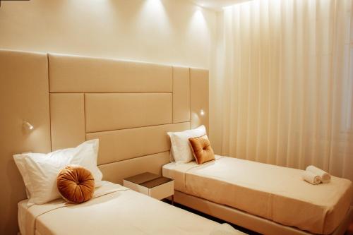 two beds in a small room with white walls at Le Premier Lisbon Suites in Lisbon