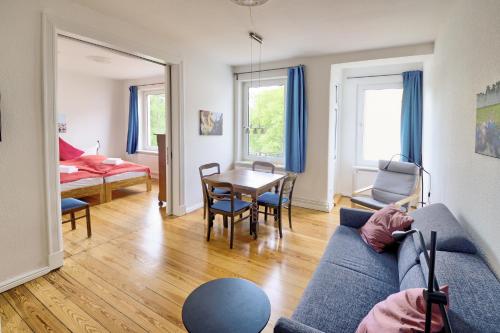フレンスブルクにあるfewo1846 - Parkblick - komfortable Wohnung mit 2 Schlafzimmern und 2 Balkonenのリビングルーム(青いソファ、テーブル付)