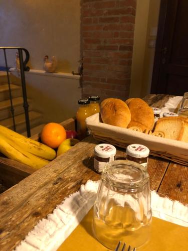 a table with a bunch of bread and fruit on it at B&B BAGOLARI in Villaganzerla