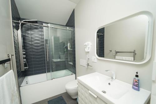 Un baño con inodoro, lavabo y espejo. en Modern home with a private Heated pool and jacuzzi, en Hamden