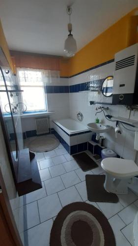 La salle de bains est pourvue d'une baignoire, de toilettes et d'un lavabo. dans l'établissement Willa Rosa, à Ciechocinek