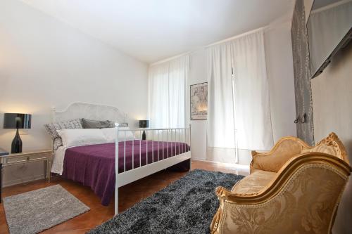 ヴェローナにあるVerona Maisonのベッドルーム1室(ベッド1台、ソファ、椅子付)