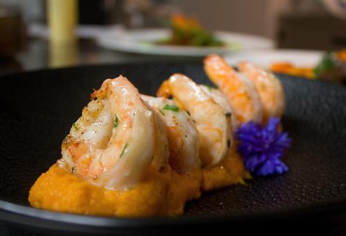 a plate of shrimp with a purple flower on it at Villa Patriot Boutique Hotel in Mariánské Lázně