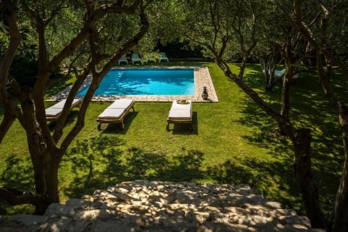 einen Blick über einen Pool in einem Garten mit Bäumen in der Unterkunft Holiday Home Radic in Klis