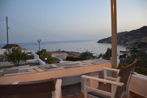 a table and chairs on a balcony with a view of the water at Avgerinou Studios in Paliochori