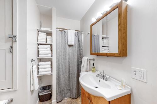 een witte badkamer met een wastafel en een spiegel bij Parkview Cottage in Bar Harbor