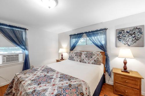 een slaapkamer met een bed en 2 ramen bij Parkview Cottage in Bar Harbor