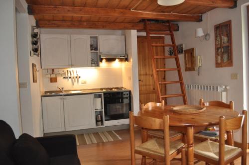 a kitchen and dining room with a table and a ladder at Appartamento ad Ovindoli in Ovindoli