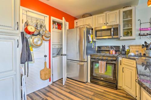 a kitchen with stainless steel appliances and orange walls at Mountain Creek Condo with Grill Walk to Lifts! in Vernon