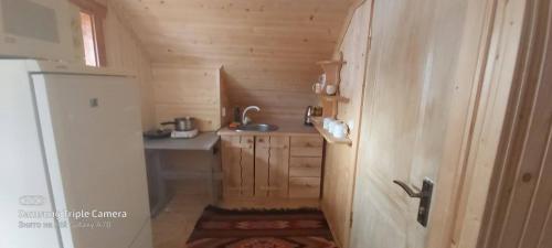 a small kitchen with wooden cabinets and a sink at У Андрушка in Vorokhta