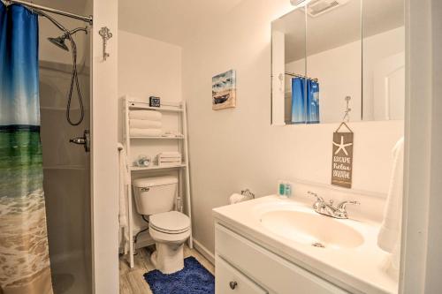 La salle de bains est pourvue d'un lavabo, de toilettes et d'une douche. dans l'établissement Cozy Central Lake Cottage about 3 Mi to Lake Michigan!, à Central Lake