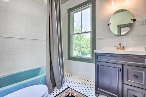 a bathroom with a tub and a sink and a mirror at The Ruebling House Cozy Defiance Apartment! in Defiance