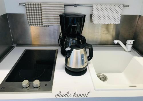 een aanrecht met een koffiezetapparaat op een aanrechtblad bij Charmant studio Kannèl au MANGANAO vue sur mer et panier d'accueil offert in Saint-François
