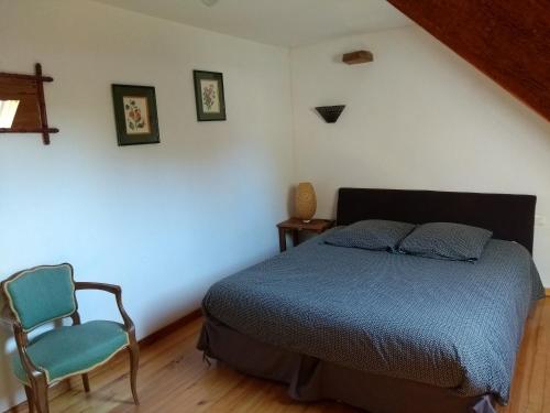 une chambre avec un lit et une chaise dans l'établissement Gîte Le Pressoir, à Catteville