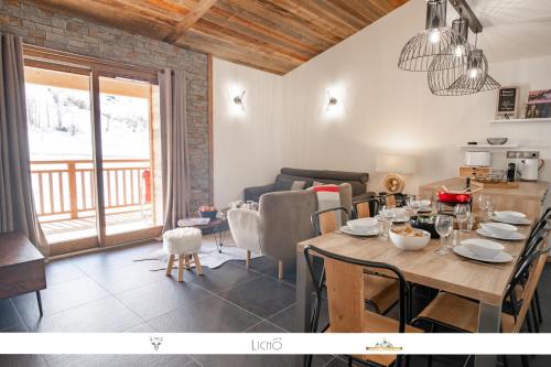 uma sala de jantar com uma mesa e uma sala de estar em MARMOTTE 204 - Charmant appartement mansardé, aux pieds des pistes em Bonneval-sur-Arc