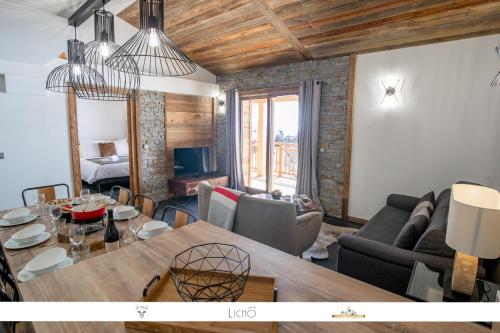 een woonkamer met een eettafel en een woonkamer bij MARMOTTE 204 - Charmant appartement mansardé, aux pieds des pistes in Bonneval-sur-Arc