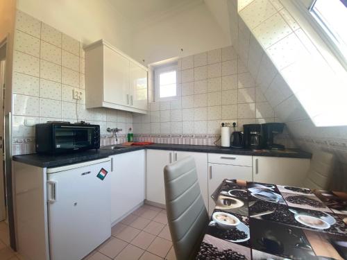 a small kitchen with a stove and a microwave at Barbara Vendégház in Balatonfüred