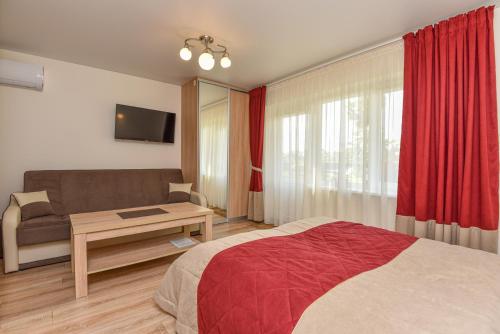 a hotel room with a bed and a couch at Vila Tante in Šventoji