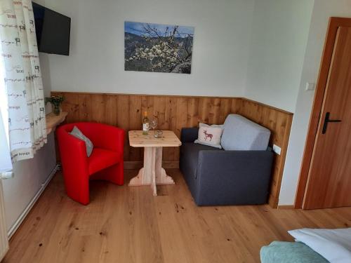 een kleine woonkamer met een tafel en 2 stoelen bij Naturidyll Brunner in Köstendorf