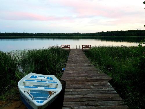 a boat sitting on a dock next to a lake at Pod żurawiem Szwałk 1 in Szwalk