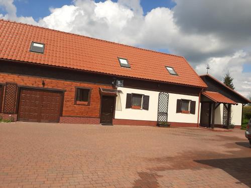 a large brick building with an orange roof at Pod żurawiem Szwałk 1 in Szwalk