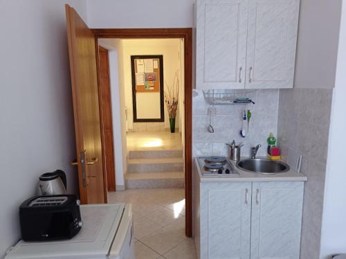 a kitchen with a sink and a door to a hallway at "Sunny" - Studio Apartment in Pula