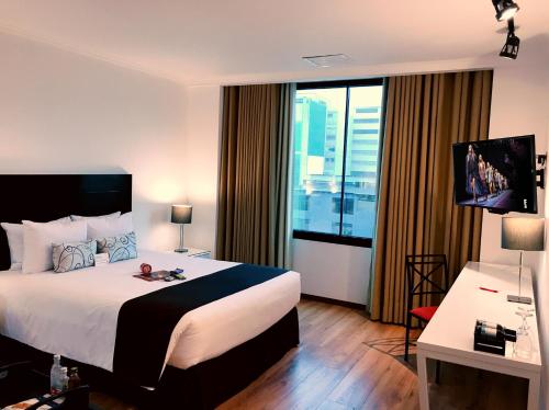 una camera d'albergo con un letto e una grande finestra di El Polo Apart Hotel & Suites a Lima