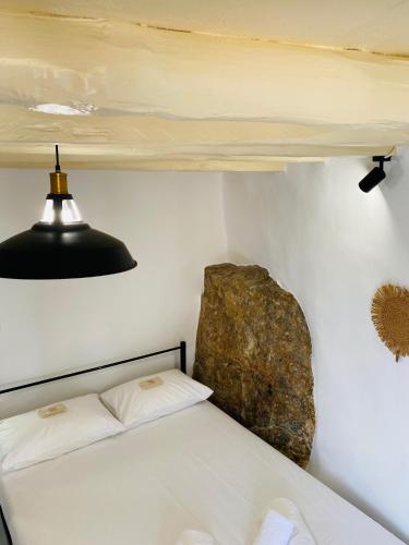 a bedroom with a bed and a rock on the wall at Litharaki Guest House in Ano Syros