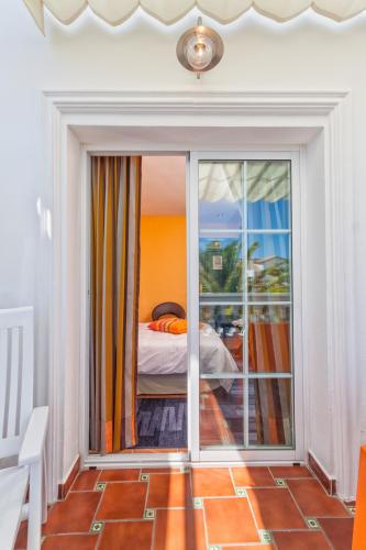 a bedroom with a view of a bed and a balcony at Boutique Hotel Pueblo in Benalmádena