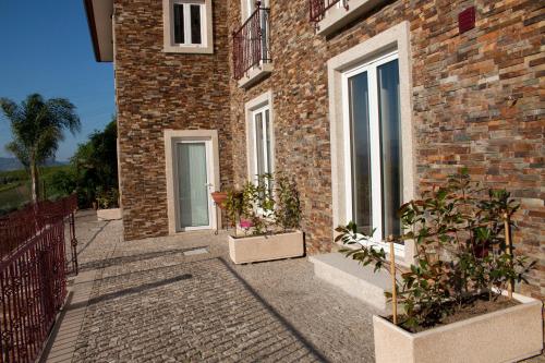 a brick building with two windows and two potted plants at Golden Mirror in Lamego