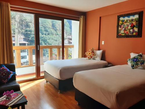 Habitación de hotel con 2 camas y ventana en USGAR Machupicchu Boutique, en Machu Picchu