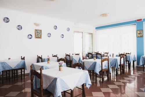 a dining room with tables and chairs with blue table cloth at Hotel Cheri in Rimini