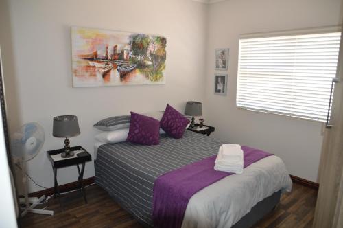 a bedroom with a bed and a painting on the wall at Piece of Paradise in Hermanus