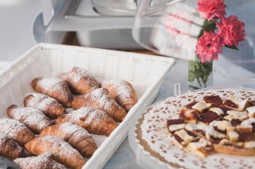 a table with two boxes of donuts and a cake at Hotel Cheri in Rimini