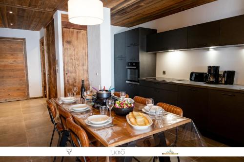 un tavolo da pranzo con sedie e una cucina di MARMOTTE 004 - Charmant appartement pour 6, aux pieds des pistes a Bonneval-sur-Arc