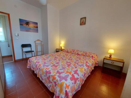 1 dormitorio con 1 cama, 2 mesas y 1 silla en Luisa 5B, en Lido di Pomposa