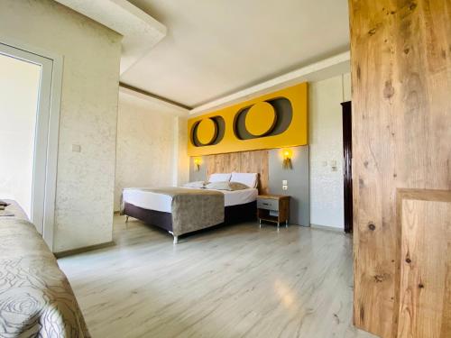Akçahan Apart Hotel في أنطاليا: غرفة نوم بسرير ولوحة صفراء على الحائط