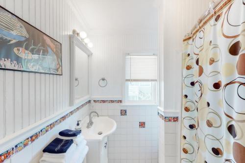 a bathroom with a sink and a shower curtain at Sunrise, Sunset in Edisto Beach