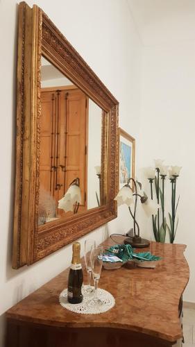 a mirror sitting on top of a wooden table with wine glasses at Amanda's Dream in Taranto