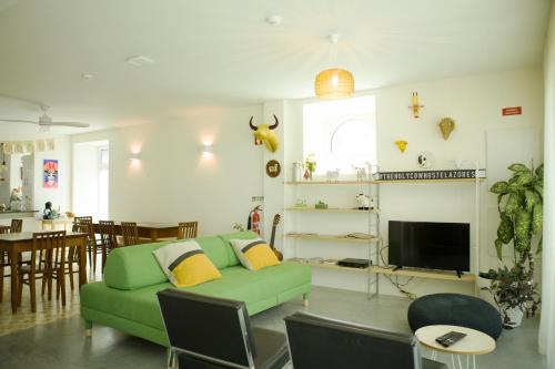 a living room with a green couch and a table at THE HOLY COW - Hostel & Suites in Ponta Delgada
